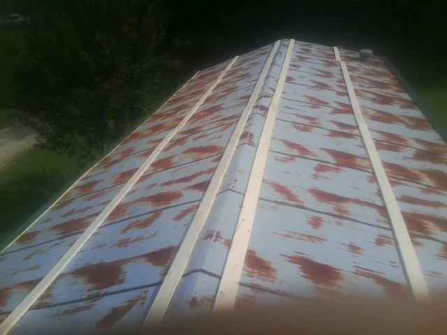Rusted metal roof panels with new wood purlins before replacement — Storm Damage Roof Repair in Bentley by Roofing Brothers