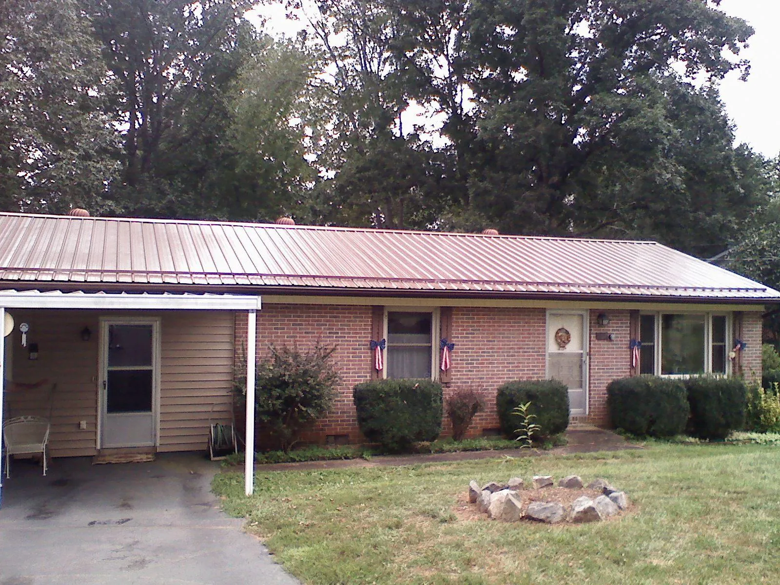 Bronze metal roof and carport on a brick ranch home — Roof Repair work by our crew in Bentley