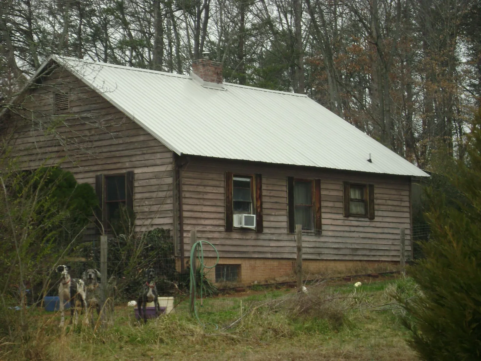 White metal roof on an old wood sided farmhouse, from a Metal Roof Installation job in Bentley